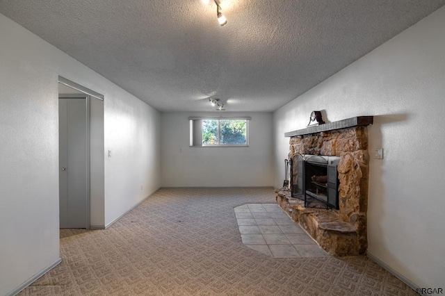 420 6th Ter, Florence, CO 81226 - unfurnished living room featuring a stone fireplace, a textured ceiling, and carpet floors