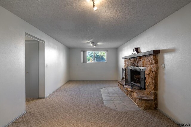 unfurnished living room featuring a fireplace, light colored carpet, and a textured ceiling