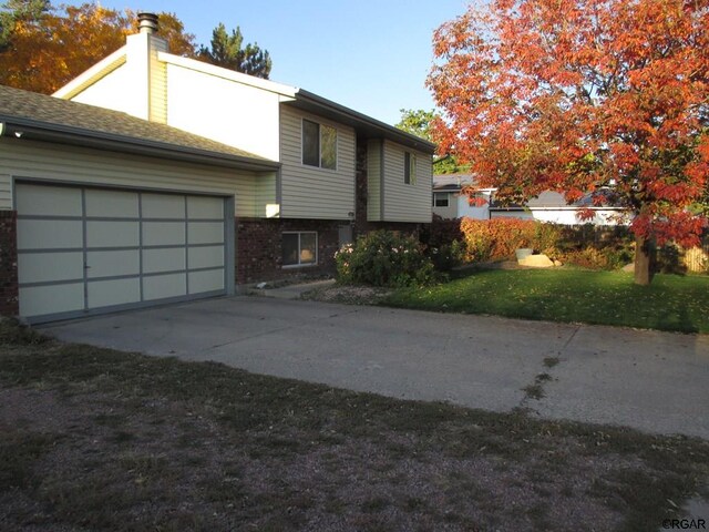 view of side of home with a garage and a lawn