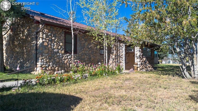 430 Broadway St, Silver Cliff, CO 81252 - view of home's exterior with stone siding, a metal roof, and a yard