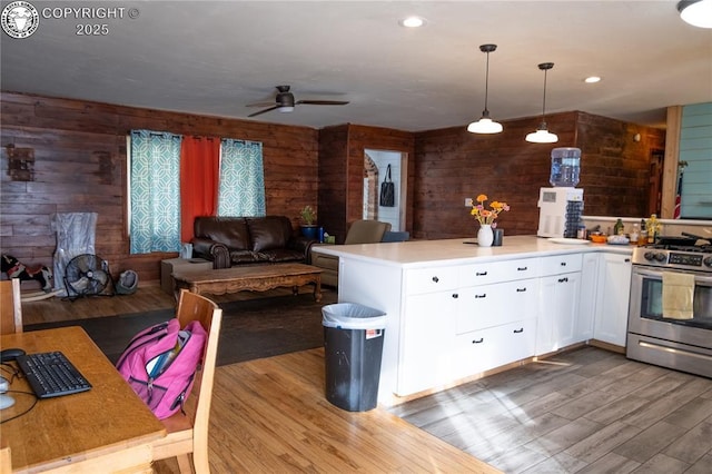 430 Broadway St, Silver Cliff, CO 81252 - kitchen featuring gas stove, wooden walls, dark wood finished floors, white cabinets, and a ceiling fan