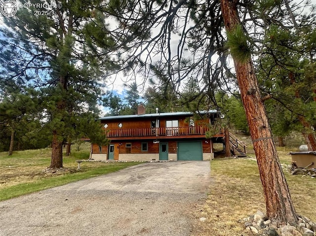 21501 Chalk Creek Dr, Nathrop, CO 81236 - view of front of property featuring aphalt driveway, stairs, an attached garage, a deck, and a chimney