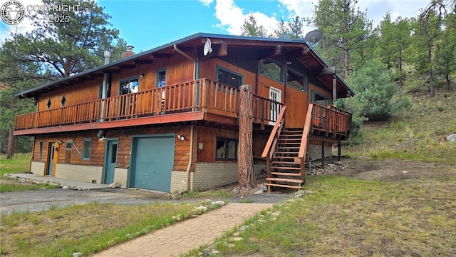 21501 Chalk Creek Dr, Nathrop, CO 81236 - exterior space featuring a deck, an attached garage, stairs, brick siding, and driveway