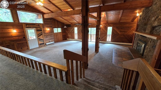 21501 Chalk Creek Dr, Nathrop, CO 81236 - interior space with wood walls, lofted ceiling with beams, carpet flooring, wood ceiling, and a stone fireplace
