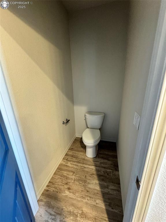 bathroom featuring hardwood / wood-style flooring and toilet