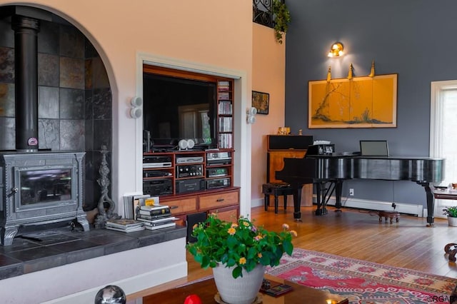 living room with a wood stove and hardwood / wood-style floors