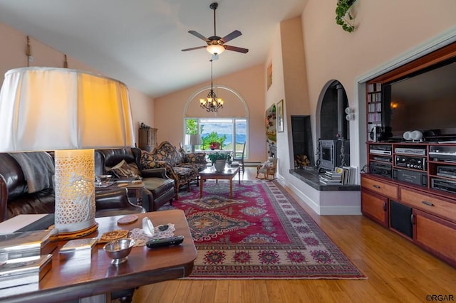 living room featuring vaulted ceiling, ceiling fan with notable chandelier, and hardwood / wood-style floors