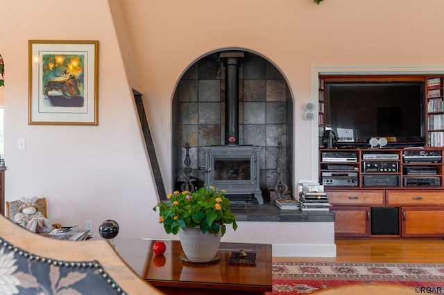 living room featuring hardwood / wood-style flooring and a wood stove