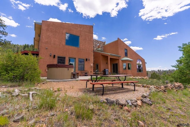 back of house featuring a hot tub