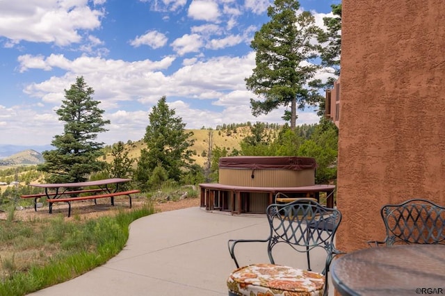 view of patio / terrace with a mountain view and a hot tub