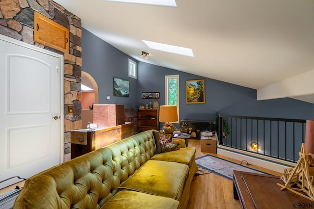 living room with hardwood / wood-style flooring and lofted ceiling with skylight