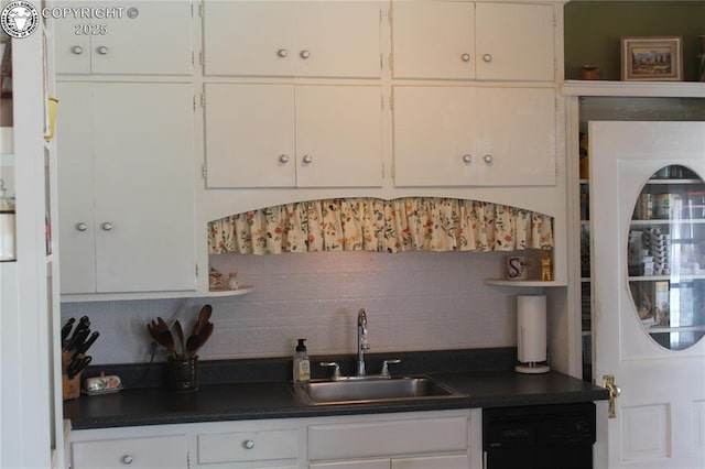 kitchen featuring dark countertops, white cabinetry, and dishwashing machine