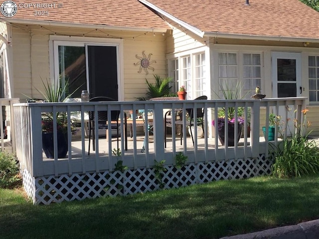 rear view of property with a shingled roof and a wooden deck