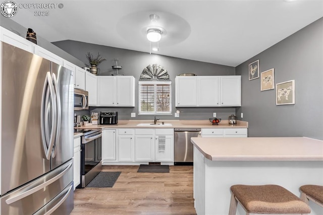 3065 Pear St, Canon City, CO 81212 - kitchen with appliances with stainless steel finishes, a sink, vaulted ceiling, light wood-style flooring, and white cabinets
