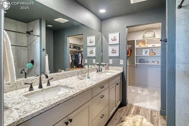 336 Arrowhead Dr, Florence, CO 81226 - bathroom with wood finished floors, a stall shower, double vanity, and a spacious closet