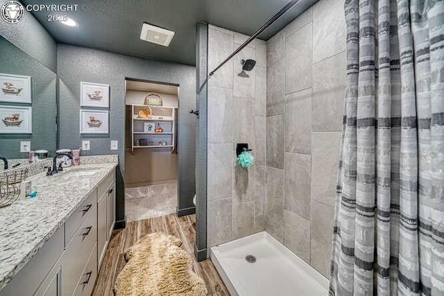 336 Arrowhead Dr, Florence, CO 81226 - bathroom with wood finished floors, vanity, and tiled shower