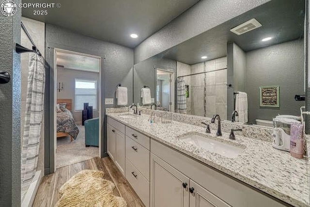 336 Arrowhead Dr, Florence, CO 81226 - bathroom with wood finished floors, double vanity, a stall shower, a textured wall, and ensuite bathroom