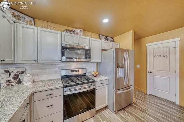 336 Arrowhead Dr, Florence, CO 81226 - kitchen with stainless steel appliances, light wood-style flooring, backsplash, light stone countertops, and recessed lighting