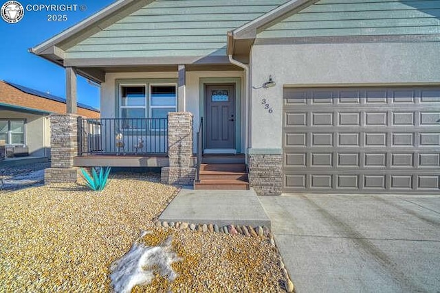 336 Arrowhead Dr, Florence, CO 81226 - property entrance featuring a porch, stucco siding, an attached garage, and driveway