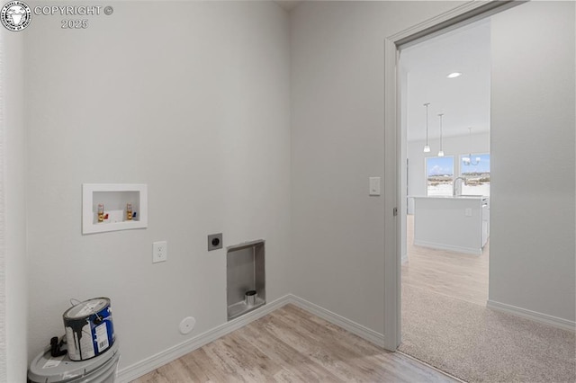 laundry area with hookup for a washing machine, hookup for an electric dryer, laundry area, baseboards, and light wood-type flooring