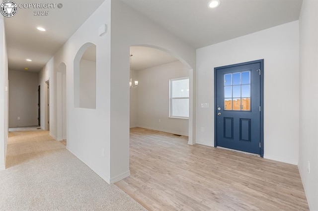 entrance foyer with light wood-type flooring, baseboards, arched walkways, and recessed lighting