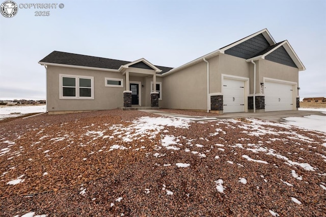 view of front of house featuring a garage, stone siding, driveway, and stucco siding