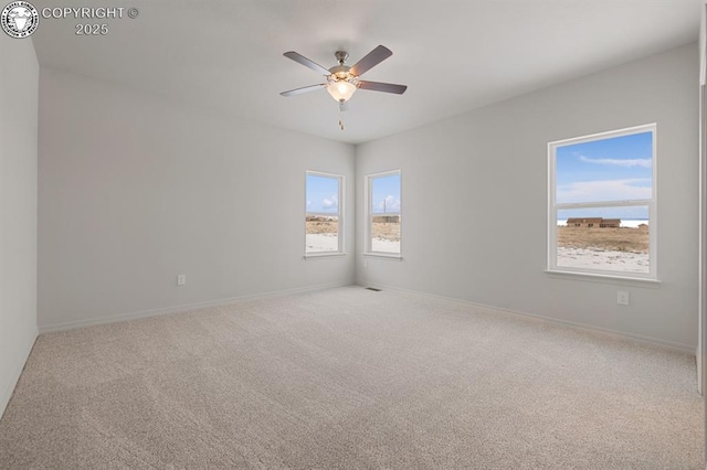 spare room with baseboards, a ceiling fan, and carpet flooring