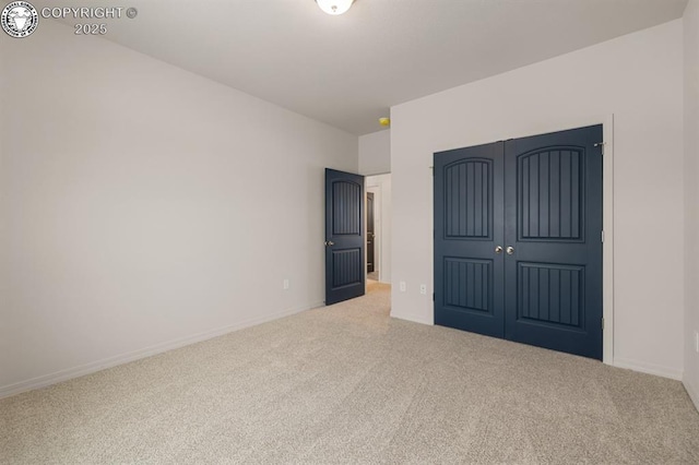 unfurnished bedroom featuring carpet, baseboards, and a closet