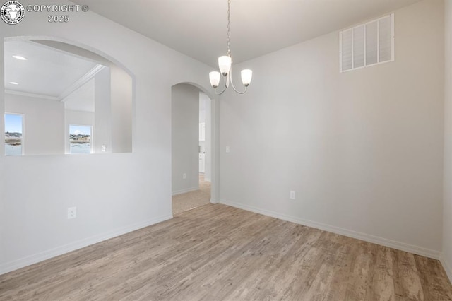 unfurnished room featuring arched walkways, recessed lighting, wood finished floors, visible vents, and baseboards