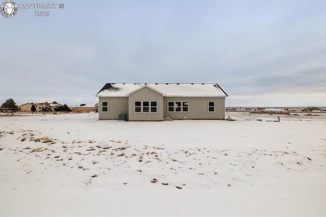 snow covered property with central AC unit