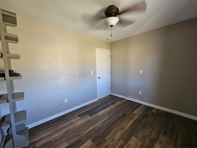 empty room featuring ceiling fan and dark hardwood / wood-style flooring