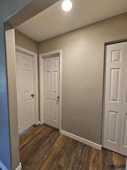 corridor with dark hardwood / wood-style floors