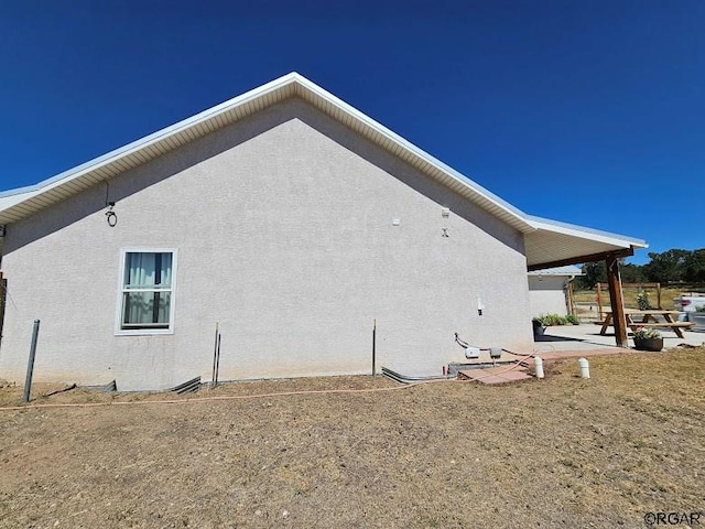 view of property exterior with a patio area