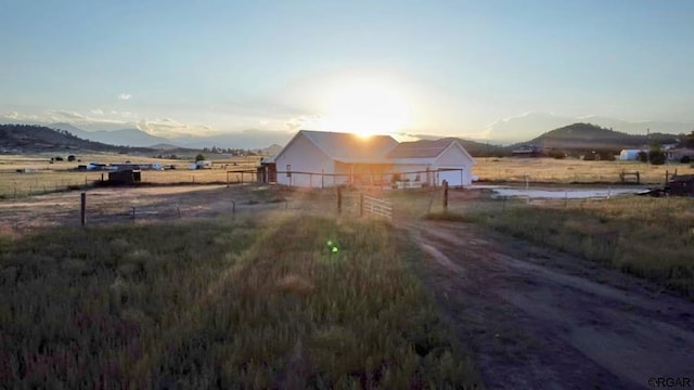 yard at dusk with a mountain view and a rural view