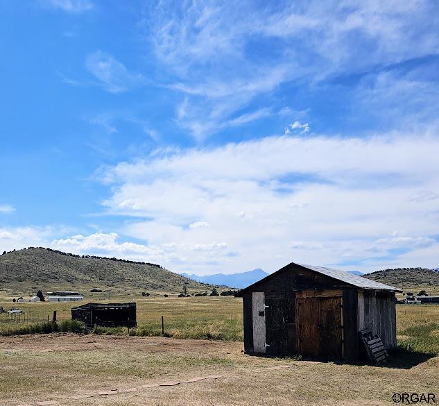 view of outbuilding featuring a mountain view and a rural view