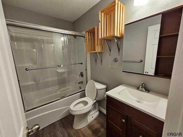 full bathroom with toilet, wood-type flooring, bath / shower combo with glass door, and vanity