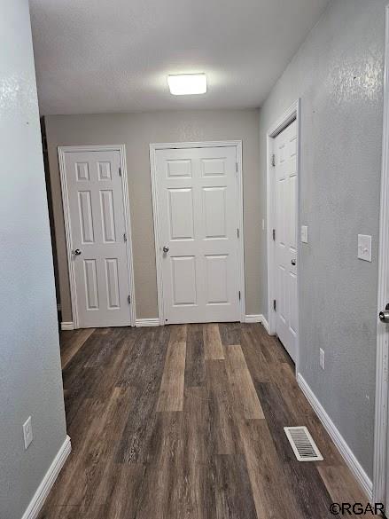 hallway with dark wood-type flooring