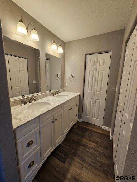 bathroom featuring wood-type flooring, vanity, and a textured ceiling