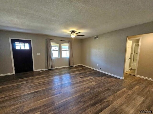 foyer entrance with dark wood-type flooring, ceiling fan, and a textured ceiling