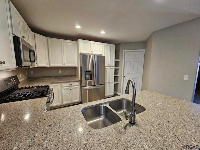 kitchen featuring white cabinetry, sink, light stone counters, and stainless steel appliances