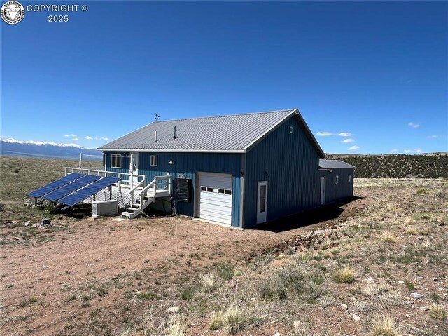 5105 Electric Ave, Westcliffe, CO 81252 - view of home's exterior with metal roof, ground mounted solar panels, and a standing seam roof