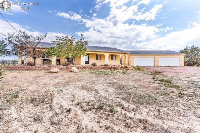 single story home featuring an attached garage, driveway, and stucco siding