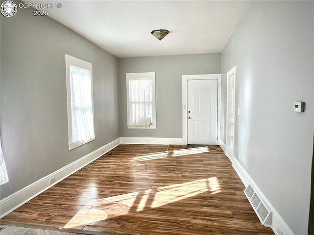 entryway with visible vents, dark wood-type flooring, and baseboards