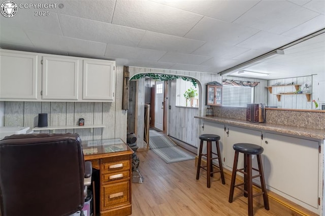 interior space with indoor bar and light hardwood / wood-style flooring