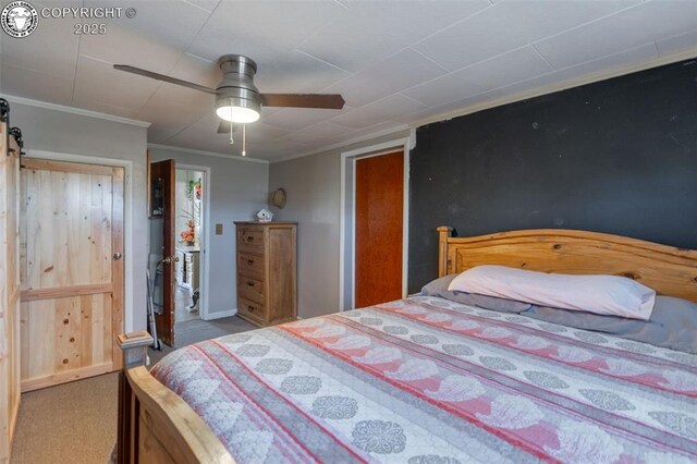 carpeted bedroom featuring crown molding, a barn door, and ceiling fan