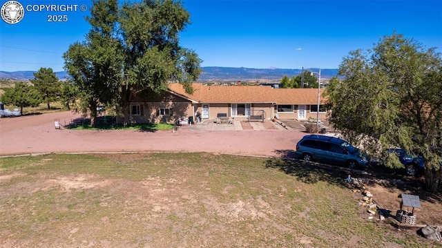 exterior space with a yard, a mountain view, and a patio