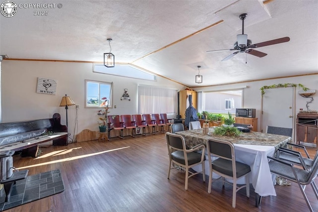 dining room featuring dark wood-type flooring, vaulted ceiling, and ceiling fan