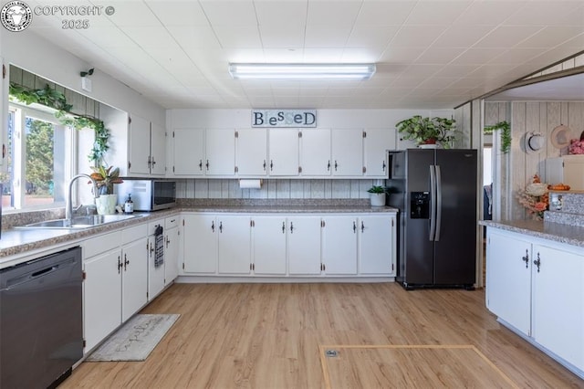 kitchen with white cabinetry, appliances with stainless steel finishes, sink, and light hardwood / wood-style flooring