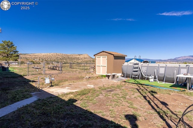 view of yard with a storage shed and a mountain view