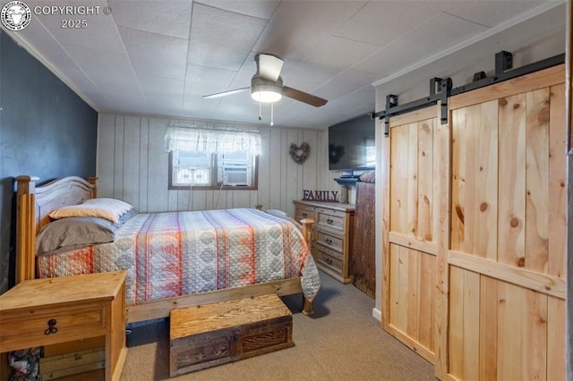 carpeted bedroom featuring a barn door and ceiling fan